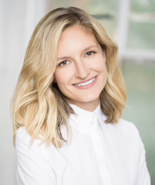 Professional headshot of Dr. Anna Konova, Associate Professor at Rutgers Robert Wood Johnson Medical School, smiling and wearing a white blouse against a softly blurred background.