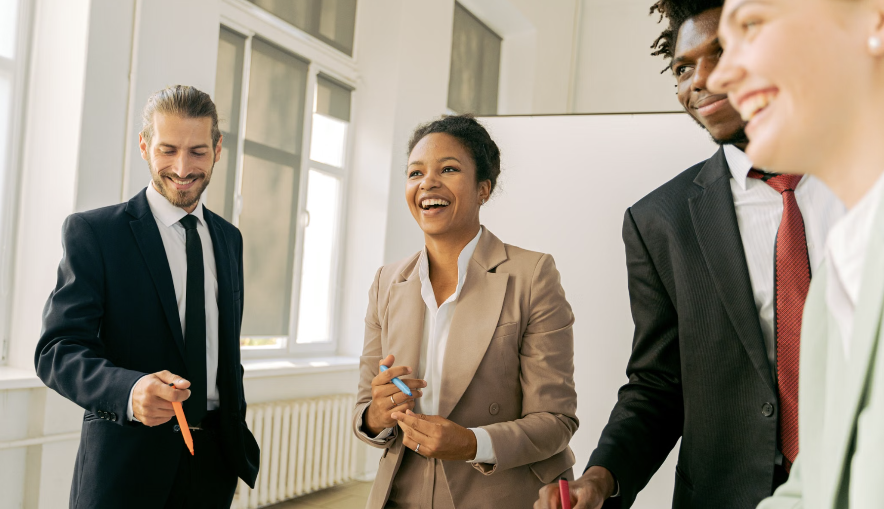 Group of professionals smiling and collaborating during a workplace meeting.