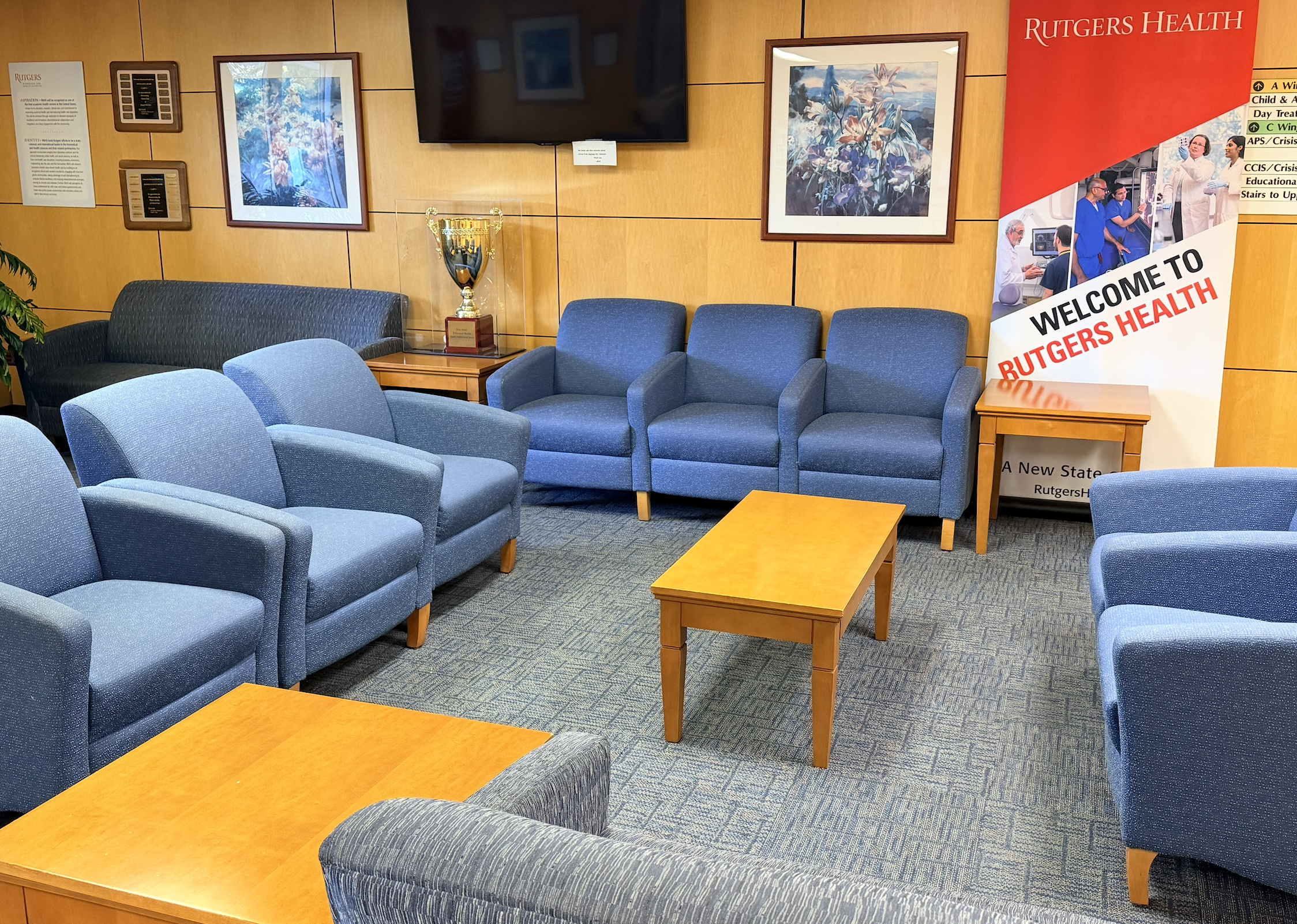 Rutgers UBHC waiting area in Piscataway with blue seating and Rutgers Health signage.