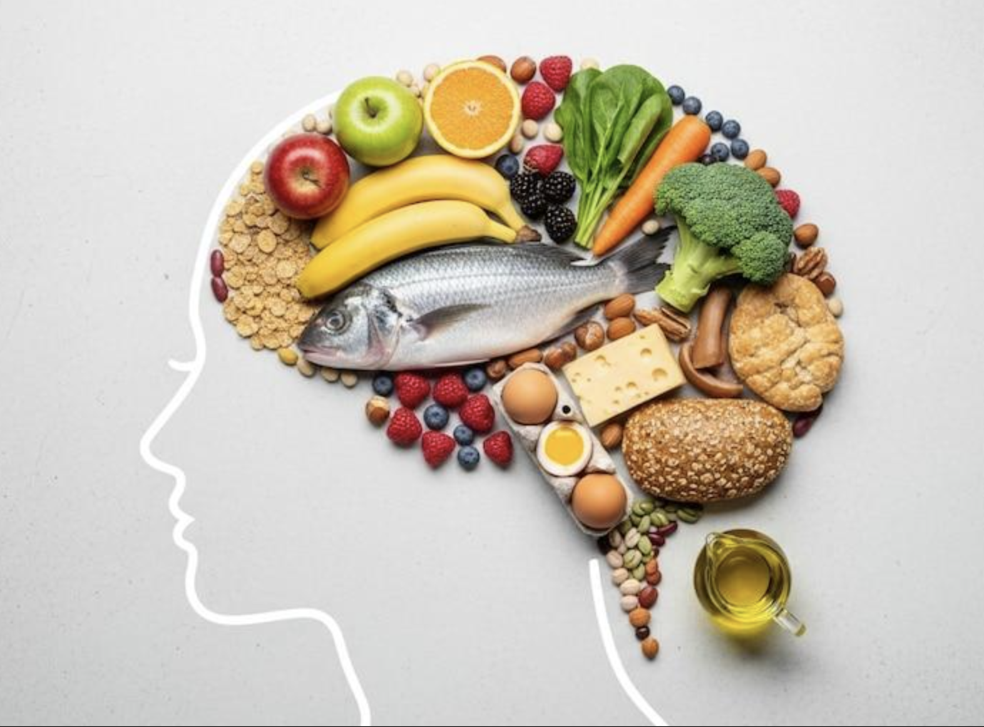 Healthy foods, including fruits, vegetables, fish, whole grains, eggs and nuts, arranged in the shape of a human brain.