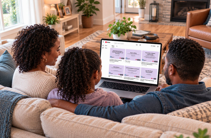 Black mother, father, and teenage daughter watching TLC suicide prevention and mental health videos together on a laptop.